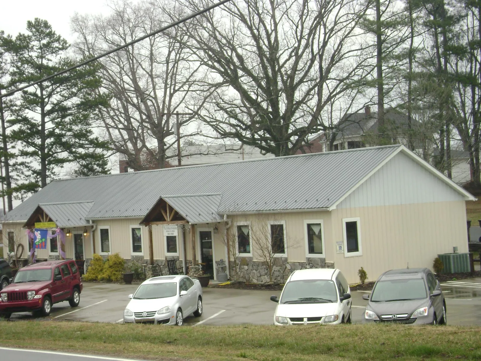 Gray metal roof with timber entry brackets on a small commercial building in Lake City